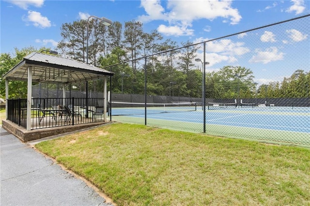 view of sport court featuring a lawn, a gazebo, and fence