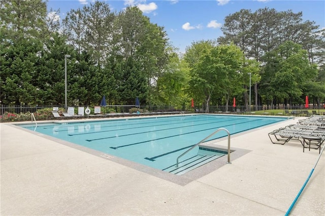 community pool featuring fence and a patio area