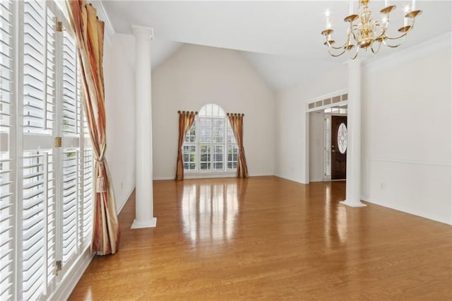 interior space with decorative columns, baseboards, lofted ceiling, an inviting chandelier, and light wood-style flooring