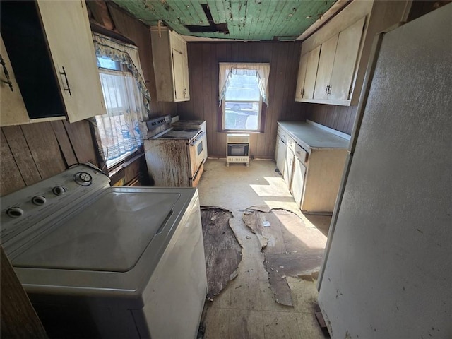 laundry room featuring cabinets, wood ceiling, heating unit, wooden walls, and washer / dryer