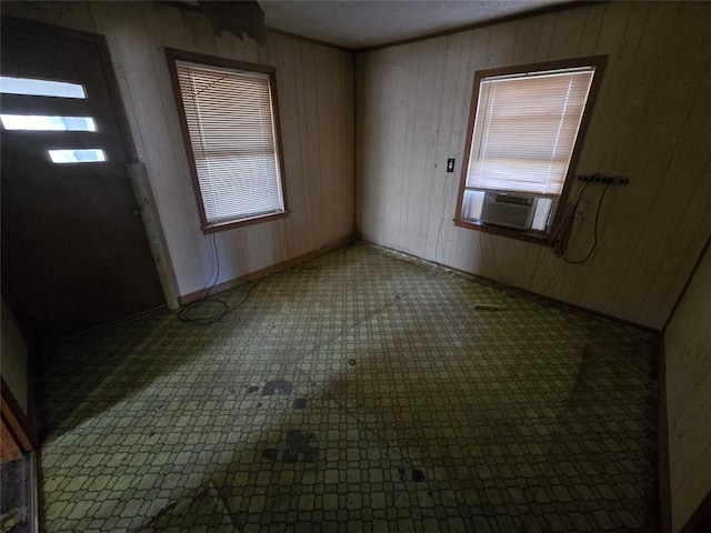 foyer entrance featuring cooling unit and wood walls