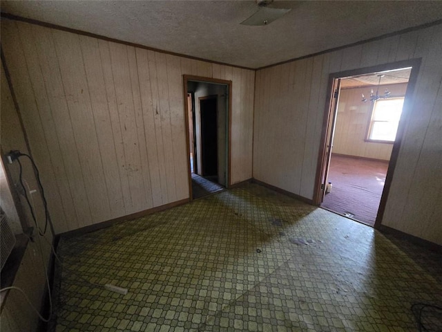 unfurnished room with a chandelier and a textured ceiling