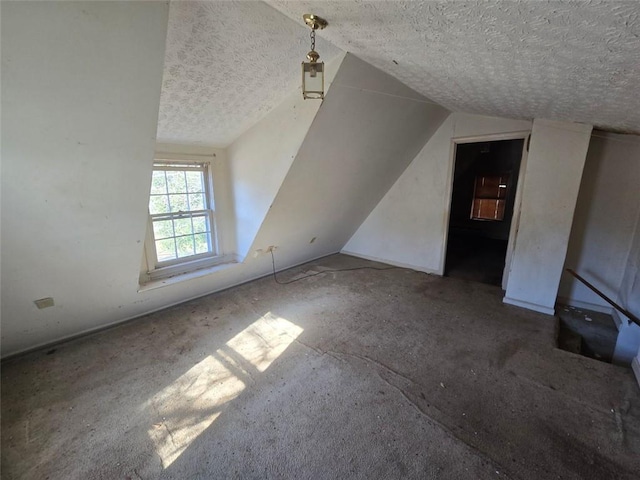 additional living space featuring vaulted ceiling and a textured ceiling