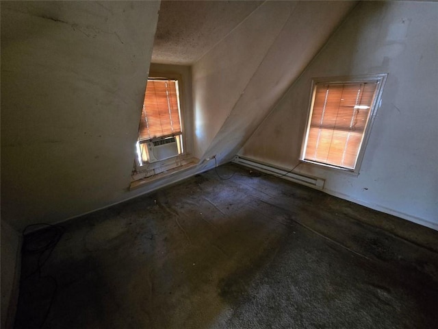 additional living space with a textured ceiling, cooling unit, vaulted ceiling, and a baseboard heating unit