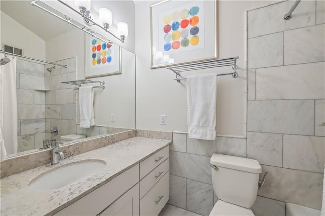 bathroom with visible vents, toilet, a shower with curtain, vanity, and tile walls