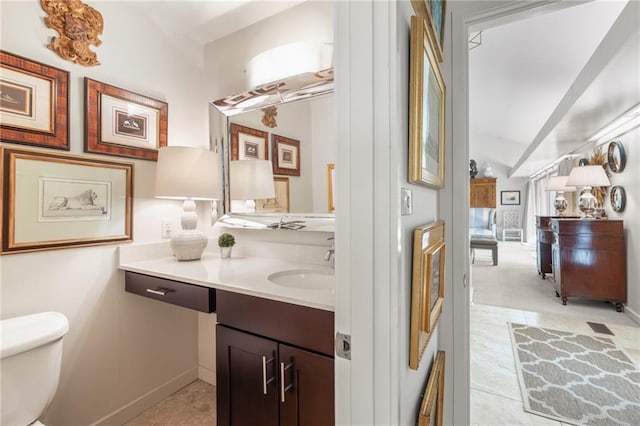 bathroom with baseboards, vanity, and toilet