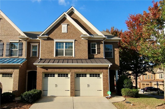 townhome / multi-family property featuring metal roof, concrete driveway, and a standing seam roof