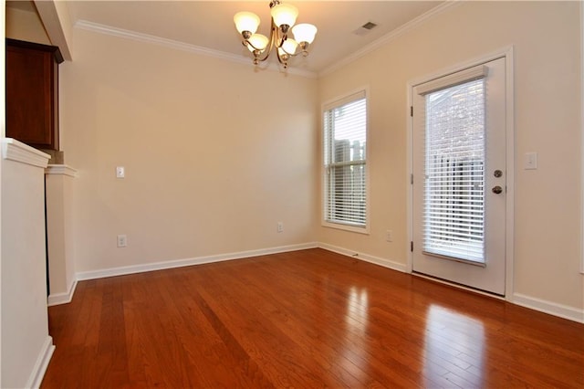 interior space featuring visible vents, wood-type flooring, an inviting chandelier, crown molding, and baseboards