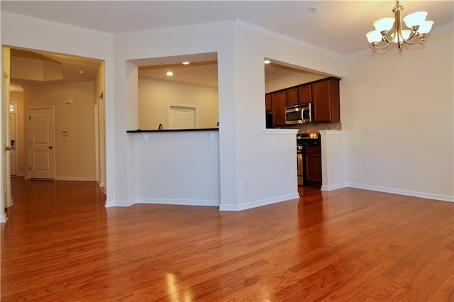 unfurnished living room featuring baseboards, an inviting chandelier, and light wood-style flooring