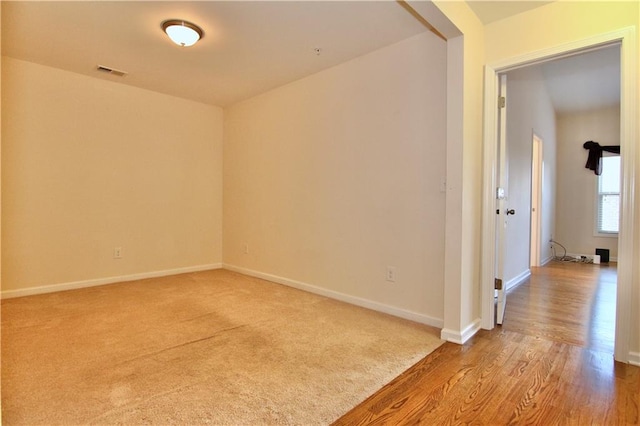 unfurnished room with carpet, baseboards, and visible vents