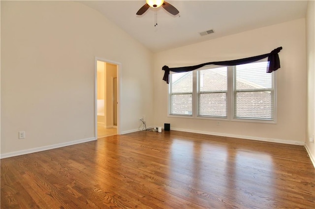 unfurnished room with visible vents, baseboards, vaulted ceiling, wood finished floors, and a ceiling fan