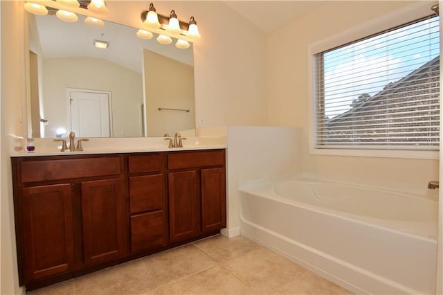 bathroom featuring lofted ceiling, double vanity, a garden tub, tile patterned floors, and a sink