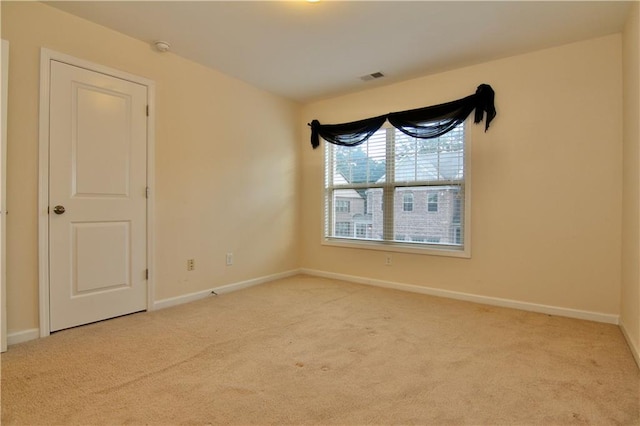 carpeted empty room with visible vents and baseboards