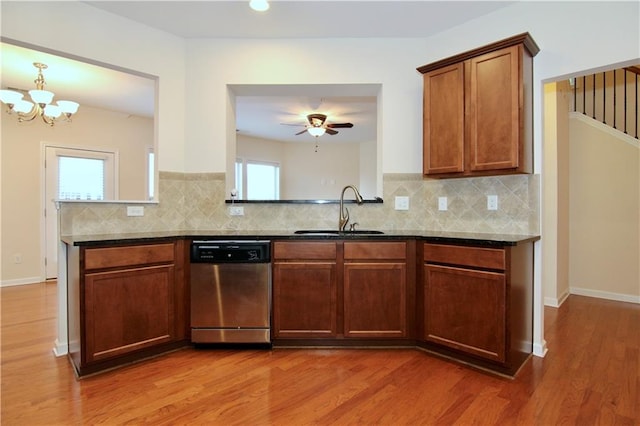 kitchen with decorative backsplash, a sink, light wood-style floors, and stainless steel dishwasher