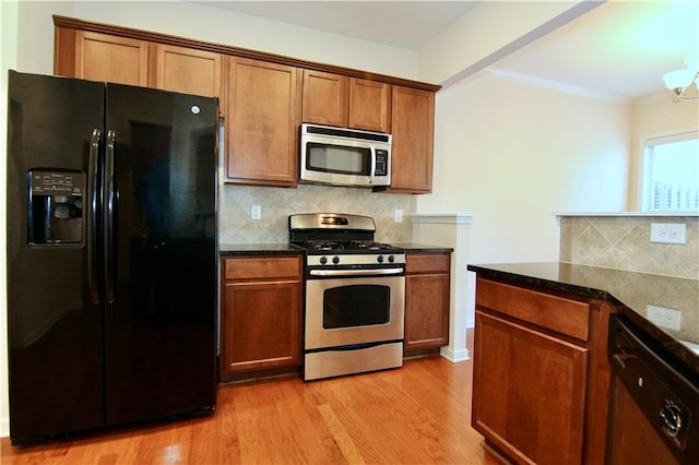 kitchen with light wood-type flooring, backsplash, appliances with stainless steel finishes, and ornamental molding