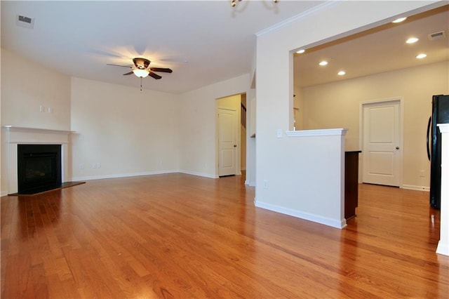 unfurnished living room featuring visible vents, light wood-style flooring, and a fireplace