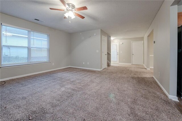 spare room featuring carpet flooring, ceiling fan, and a textured ceiling