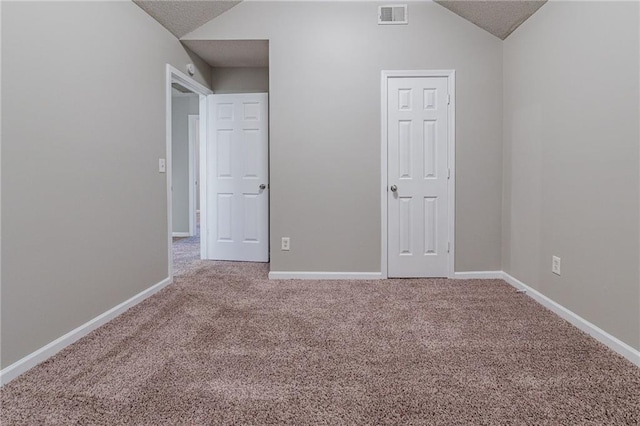 unfurnished bedroom with carpet flooring and lofted ceiling