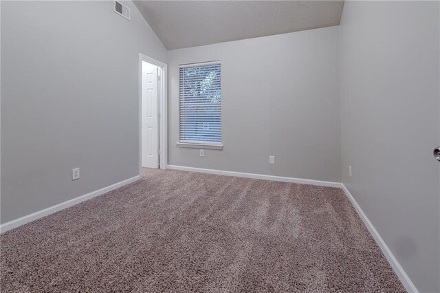 unfurnished room featuring carpet floors and vaulted ceiling