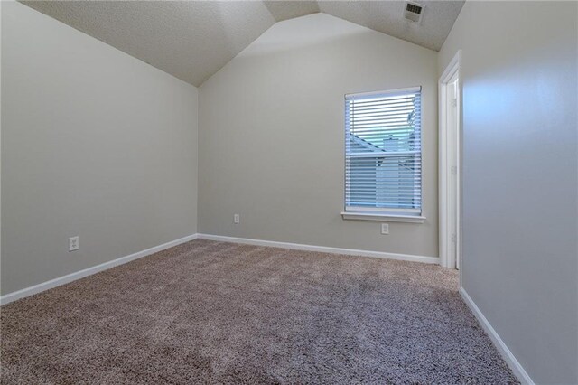 carpeted empty room with a textured ceiling and vaulted ceiling