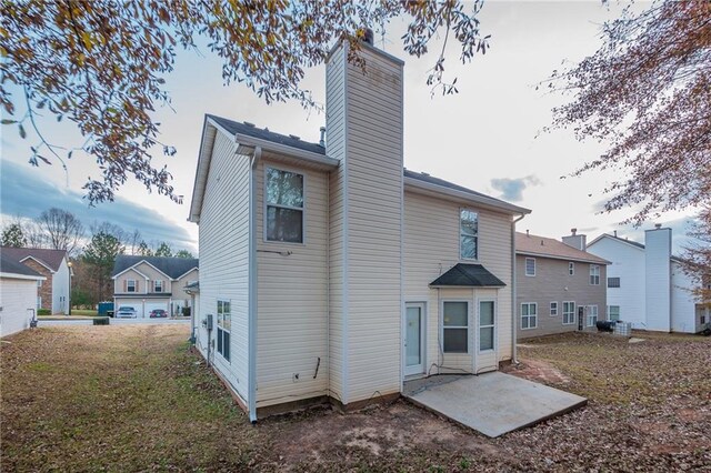 back of property with a yard and a patio area