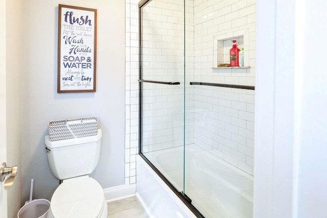 109 Lighthorse Blvd, Mcdonough, GA 30252 - bathroom featuring toilet, baseboards, and combined bath / shower with glass door