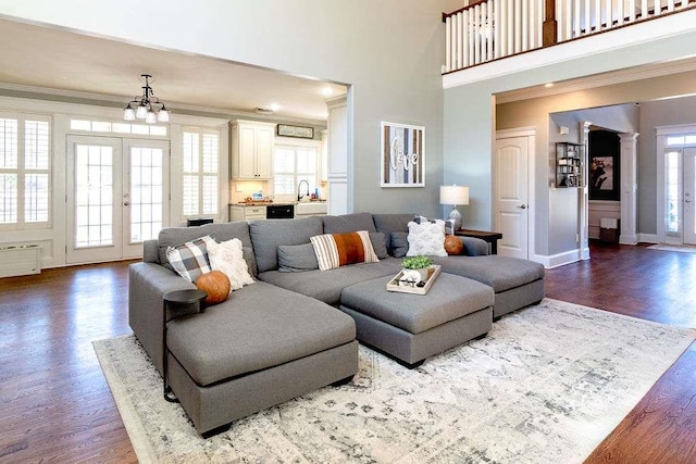 109 Lighthorse Blvd, Mcdonough, GA 30252 - living room featuring crown molding, wood finished floors, a towering ceiling, baseboards, and a chandelier