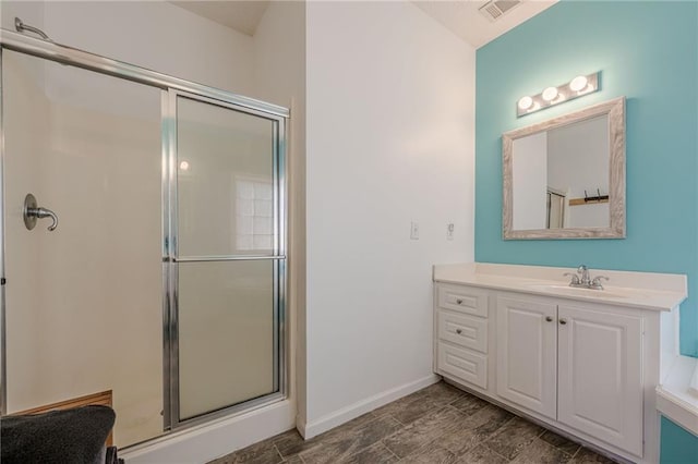 full bath featuring a shower stall, visible vents, baseboards, and vanity