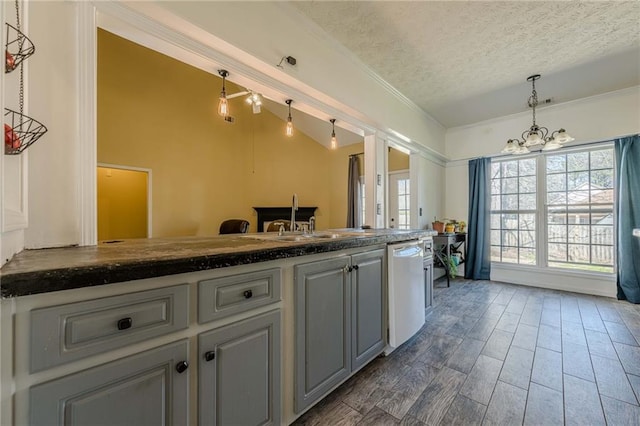 kitchen featuring a notable chandelier, dark countertops, a textured ceiling, wood finished floors, and dishwasher