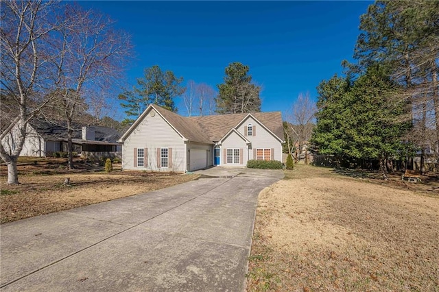 view of front of property featuring a front lawn, concrete driveway, fence, and an attached garage