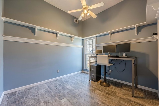 office space with ceiling fan, high vaulted ceiling, wood finished floors, visible vents, and baseboards