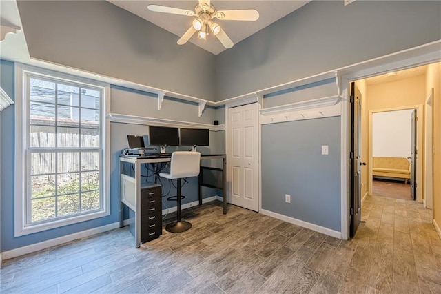 home office featuring high vaulted ceiling, wood finished floors, a ceiling fan, and baseboards