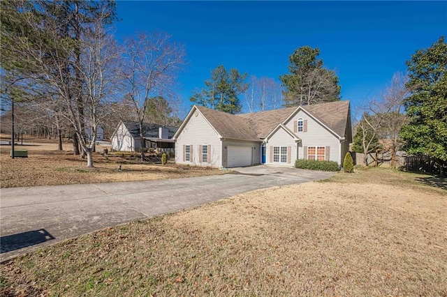 view of front facade with driveway, an attached garage, fence, and a front lawn