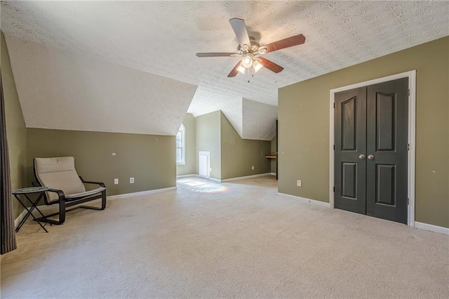 unfurnished room with a textured ceiling, carpet flooring, and baseboards