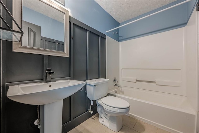 bathroom featuring toilet, tile patterned flooring,  shower combination, and a textured ceiling