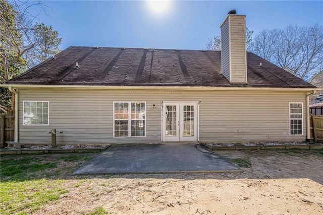 rear view of house with french doors, fence, a chimney, and a patio