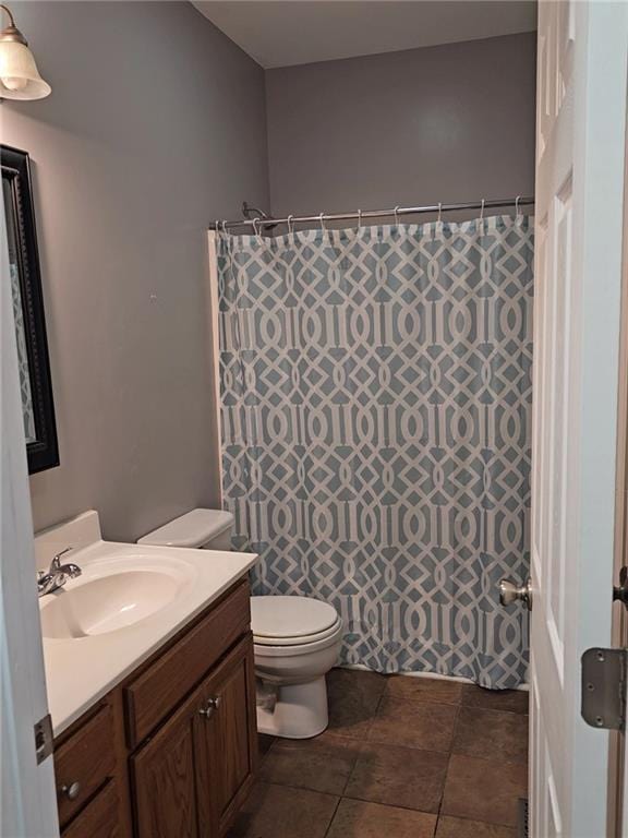 bathroom featuring vanity, toilet, and curtained shower