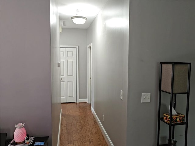 hall with wood finished floors and baseboards