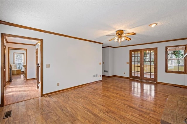 unfurnished room featuring visible vents, french doors, a textured ceiling, and light wood-style floors