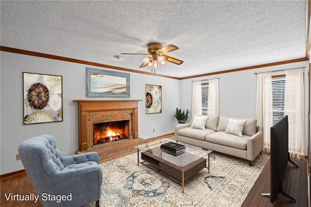 living area featuring a fireplace, a textured ceiling, crown molding, and wood finished floors