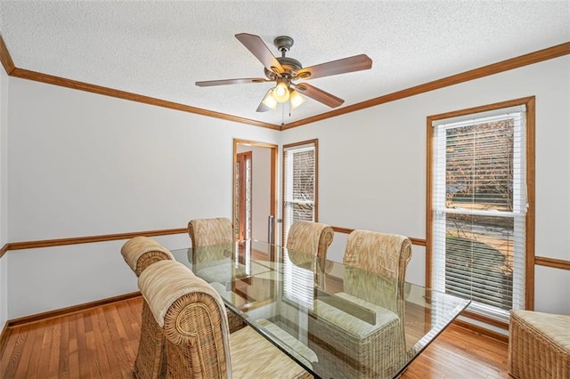 dining room with ornamental molding, a textured ceiling, and hardwood / wood-style floors