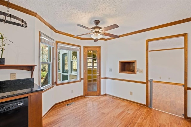 unfurnished dining area featuring crown molding, baseboards, light wood-style floors, a textured ceiling, and a ceiling fan