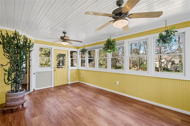 unfurnished sunroom featuring a wealth of natural light, wooden ceiling, and a ceiling fan