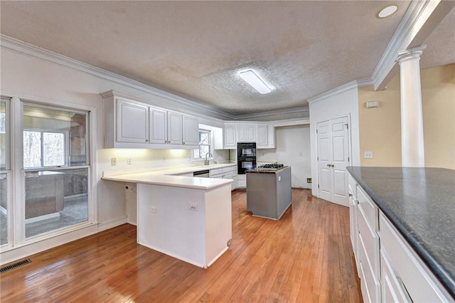 kitchen featuring crown molding, white cabinets, and light hardwood / wood-style flooring