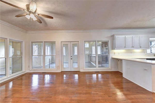 kitchen featuring french doors, white cabinetry, dark hardwood / wood-style floors, ceiling fan, and ornamental molding