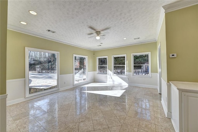 tiled spare room featuring ornamental molding, a textured ceiling, and ceiling fan