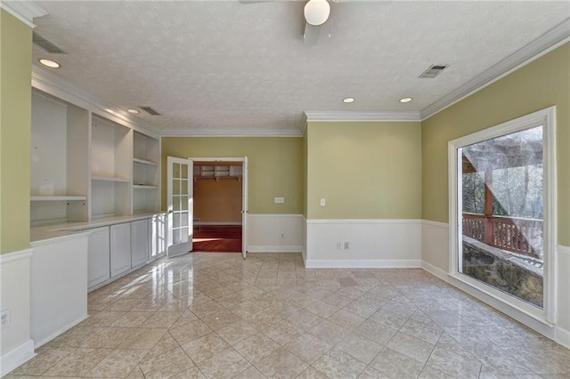 tiled empty room featuring ceiling fan, a textured ceiling, french doors, and ornamental molding