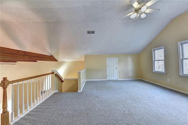 bonus room with light carpet, lofted ceiling with beams, a textured ceiling, and ceiling fan