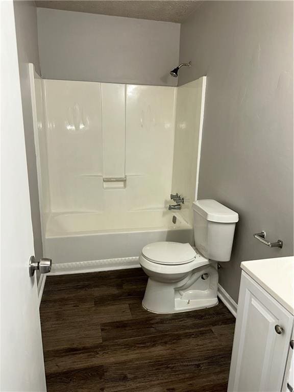 full bathroom featuring a textured ceiling, shower / tub combination, wood-type flooring, vanity, and toilet