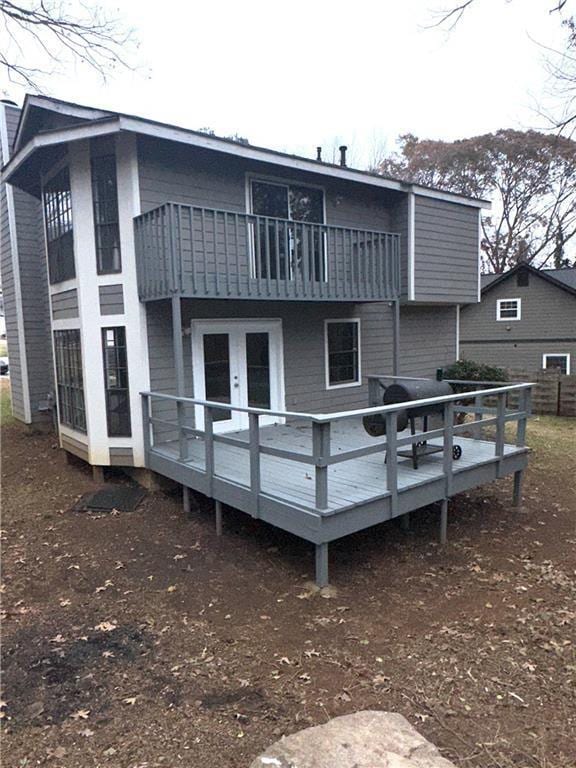 back of house featuring french doors, a deck, and a balcony